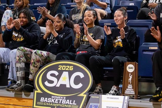 Coker is all smiles looking on at the SAC women's basketball championship.